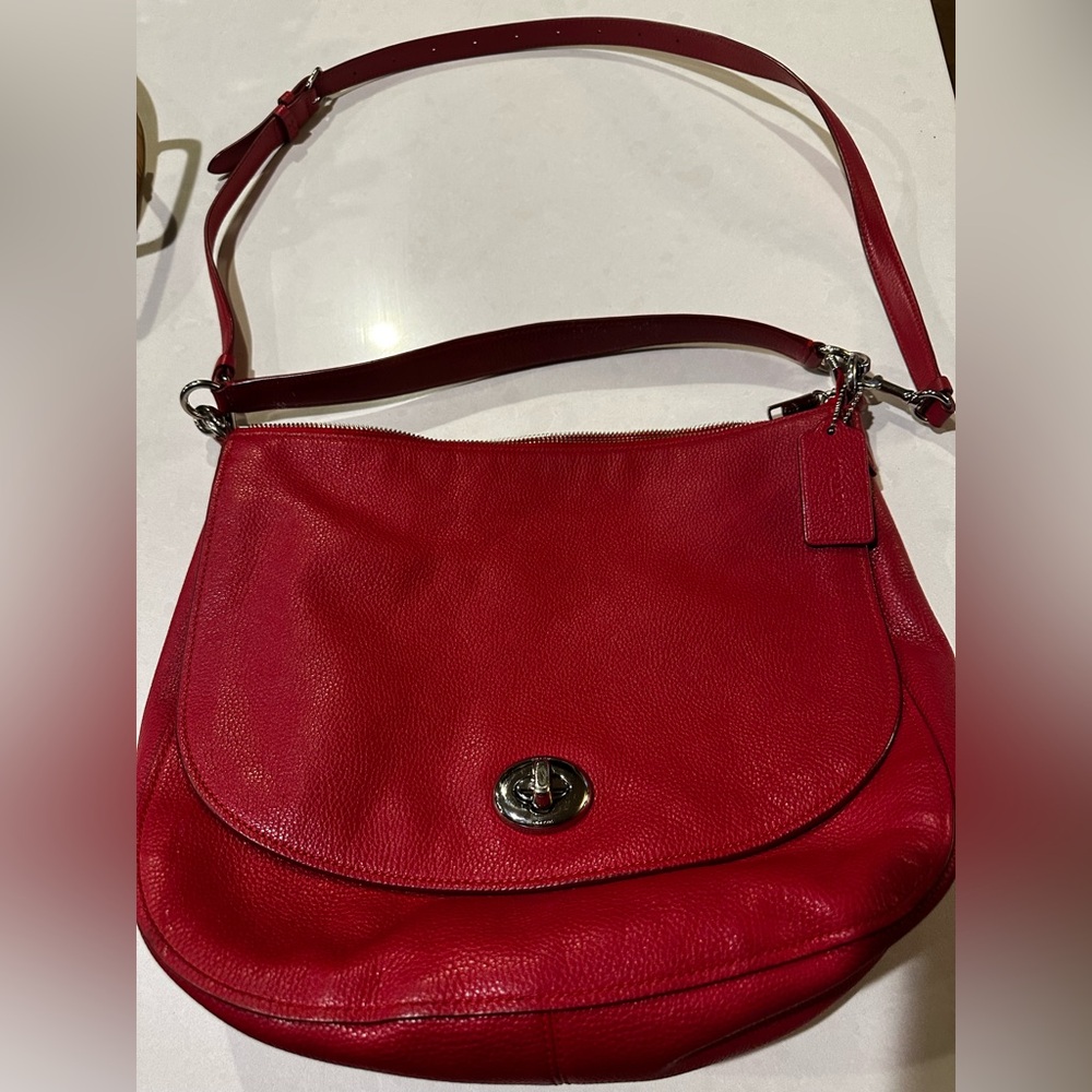 Coach Handbag with shoulder strap and crossbody strap.